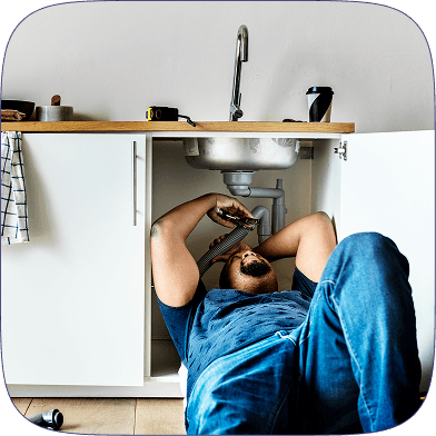 Plumber working under sink